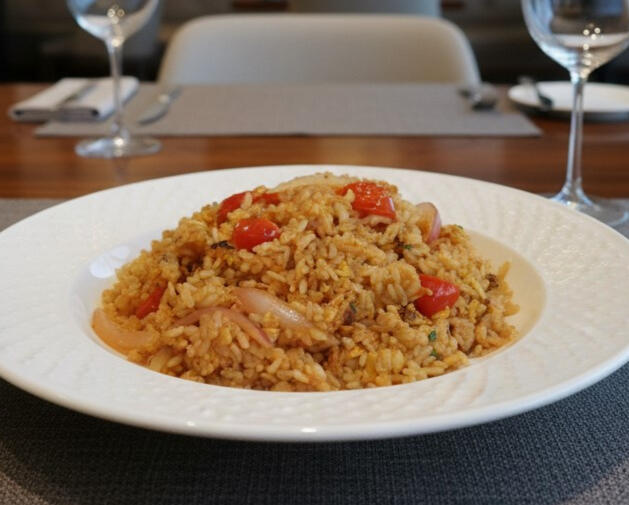 Thai fried rice with chicken, egg, tomatoes and onions, served as a generous portion.