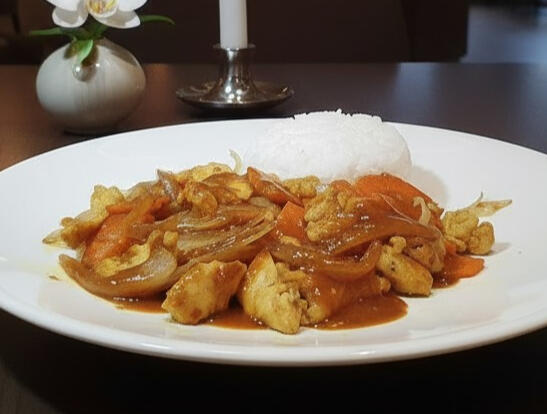 Stir-fried chicken satay with steamed rice, featuring marinated chicken breast, carrots and onions topped with rich satay sauce.
